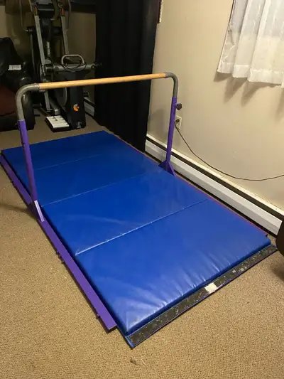 Gymnastics bar with adjustable bar and gym mat Dimensions: Frame is 90” long and 54” wide Cross bar...
