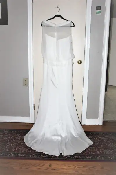 This is a strappless elegant wedding dress with a fine nylon net on top that open at the back and on...