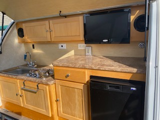 Outdoor kitchen with fridge, stove. Solar panel. Propane tank. Banquette converts to queen bed. Stor...