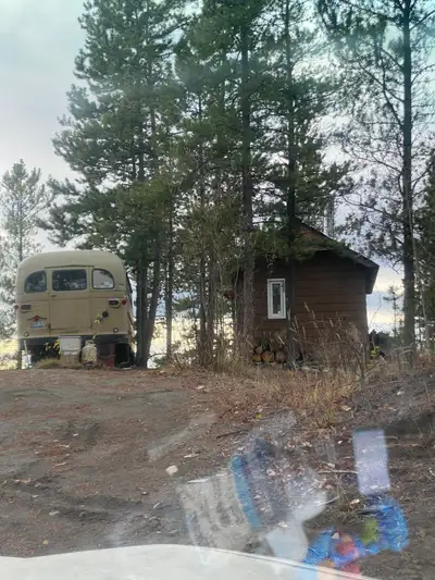 Great view, woodstove, outhouse, blue jug , no power generator ok. Comes with camper bus for storage...