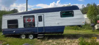 This pre-owned fifth wheel camper features a durable blue and white exterior with tandem axles, perf...