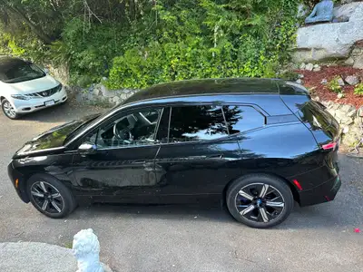 Take over the lease on this stunning 2024 BMW iX xDrive40 in Sapphire Black — one of the most head-t...