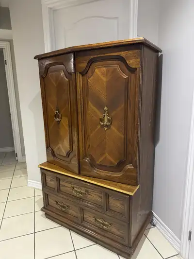 This solid wood armoire offers ample storage space with its cabinet and three drawers. It's in good...