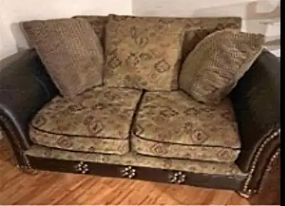 Causeuse assez massive en cuir capitonnée, coussins en tissu à donner