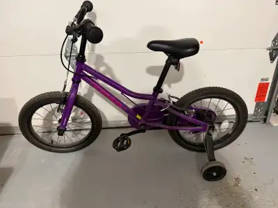 Garneau kids bike features sturdy 16-inch wheels and a vibrant purple frame with removable training...