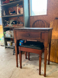Antique Sew Machine in cabinet with seat and all accessories.