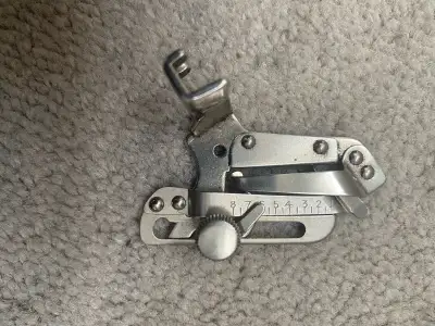 This is a used sewing machine binder attachment, perfect for hemming and creating a professional edg...