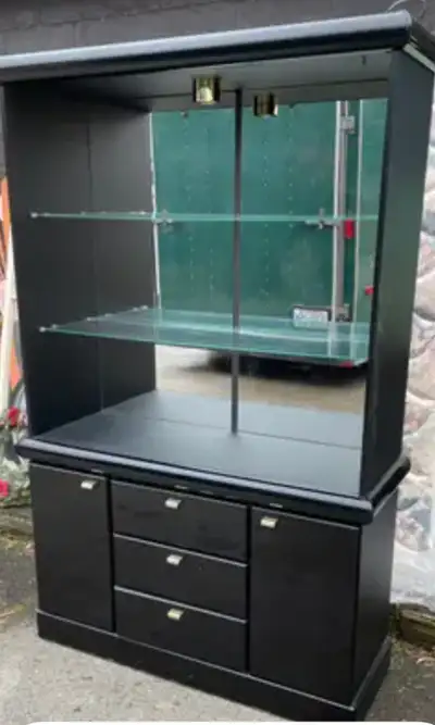 Black hutch for sale has three tier glass shelves for displays. Still in excellent condition. Has a...