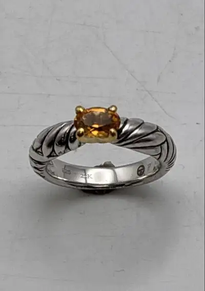 Gorgeous hand made Sterling silver ring, with 22 karat gold accent holding a lovely and clear orange...