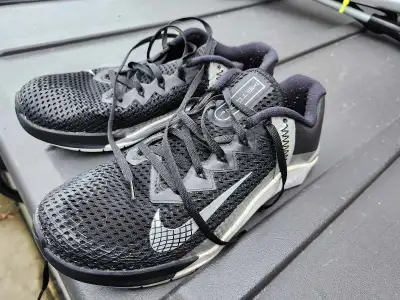 These Nike Metcon 7 training shoes are black with silver accents. They are a US women size 9, UK siz...