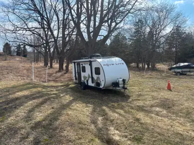 16' RV trailer with electric brakes, 30 lb propane tank, double bed, kitchen, stove, frig, propane f...