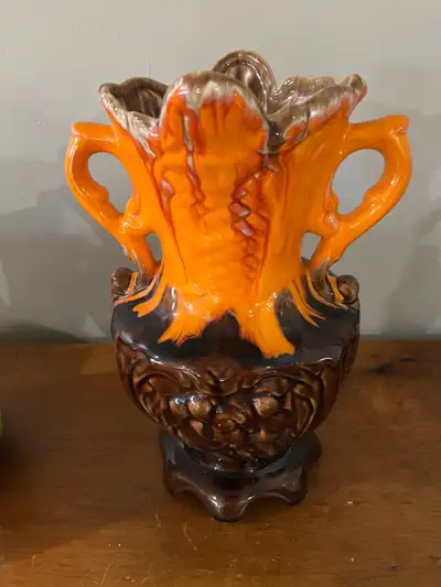 This is a striking vintage vase featuring a vibrant orange glaze on its upper half, which transition...