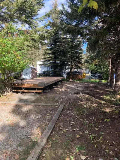 Lot – 65’ long x 38’ wide Includes deck (24’x 8’), small shed and portable firepit (trailer has been...