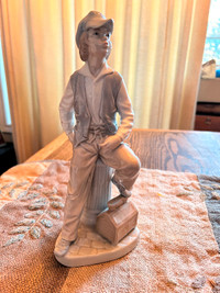 Lladro boy 10” high and 4” wide, leaning against fire hydrant.