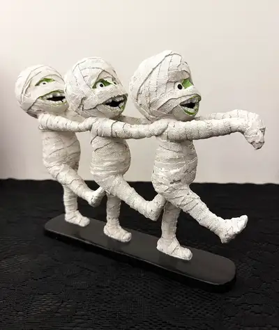 NWOT cute mummy trio statue figurine. It measures 9" L x 8" H in size, it's made of resin & the pain...