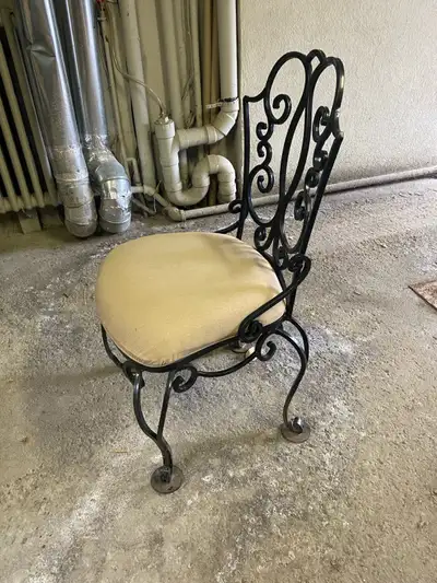 10 black, wrought iron chairs with removable, upholstered seats -scrolled designs on backs and legs...