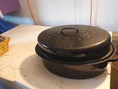 This is a used black roasting pan with white speckles, perfect for cooking a turkey or other large r...