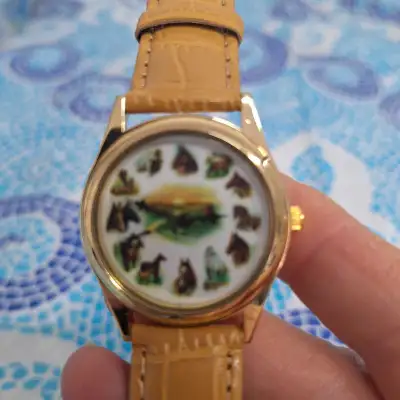 This is a used horse watch, which features various horse images around the face. It is in good condi...