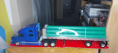 New Ray Volvo VN-780 Truck W/Flatbed & Long Pipes - 1/32 Scale, View more