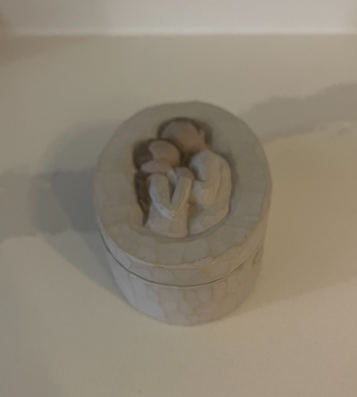 Oval sculptured resin keepsake box designed by Susan Lordi Carving of a loving couple's embrace is h...