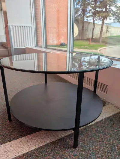 Black coffee table glass top Circle shape 29 inches 18 inches tall Pick up location old Calgary Haro...