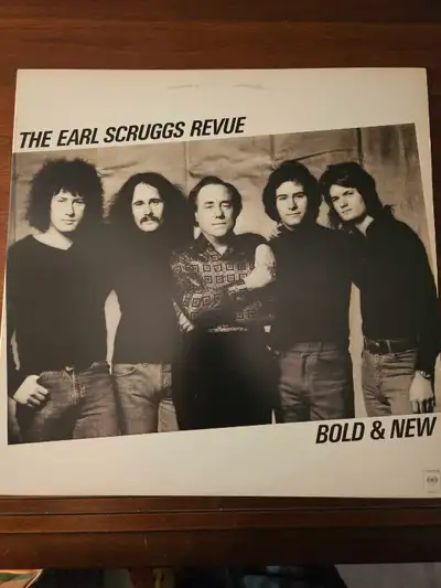 Own a piece of music history with this Earl Scruggs Revue - Bold & New vinyl record! This vintage LP...