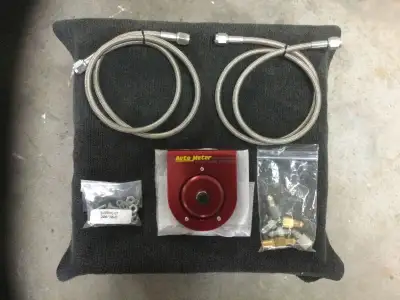 Auto meter fuel isolator. New, never used, comes with two 3ft. Steel braided fuel lines and fittings...
