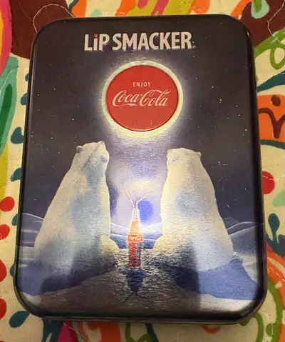 This is a Lip Smacker tin featuring six lip balms. Flavours include Coca-Cola, Vanilla, Cherry, Blac...