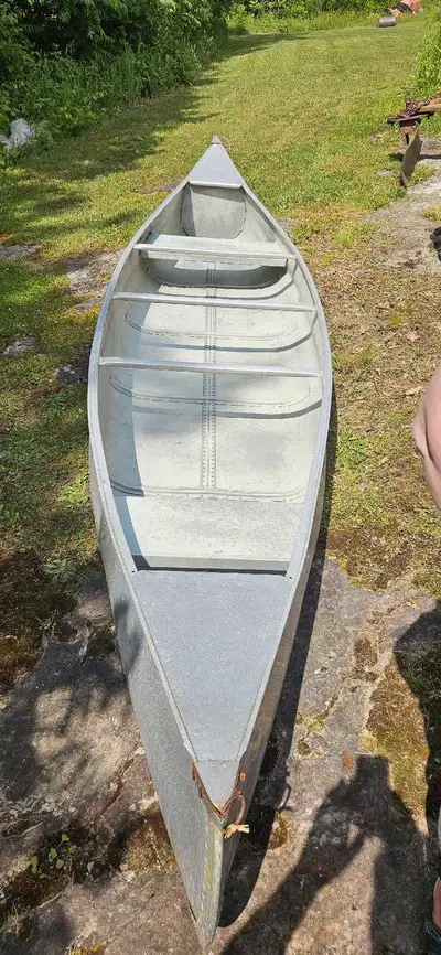 This is a used 16-foot aluminum canoe, perfect for leisurely paddles on the lake. While it shows sig...