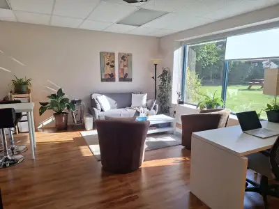 Très grand bureau professionnel divisé en plusieurs zones : espace divans, grand bureau de travail,...