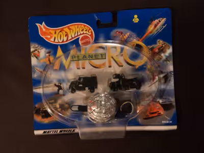 This comes with a couple black micro trucks, a black trailer with a silver UFO and a micro figurine...