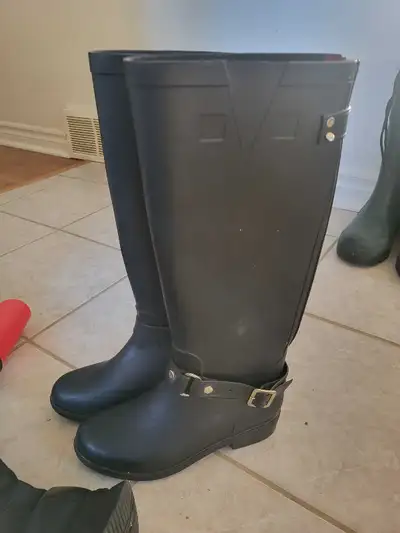 These are used Hunter brand rain boots in a size 37, featuring a sleek black design and adjustable b...