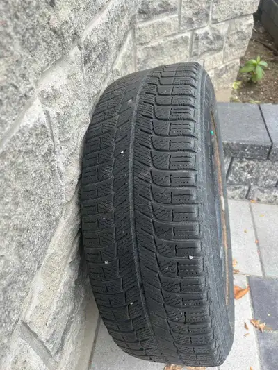 This is a Michelin X-Ice winter tire, size 215/60R16, mounted on a steel rim. It is in used conditio...