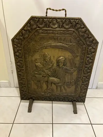 Add a touch of vintage charm to your hearth with this ornate fireplace screen. The embossed brass ar...