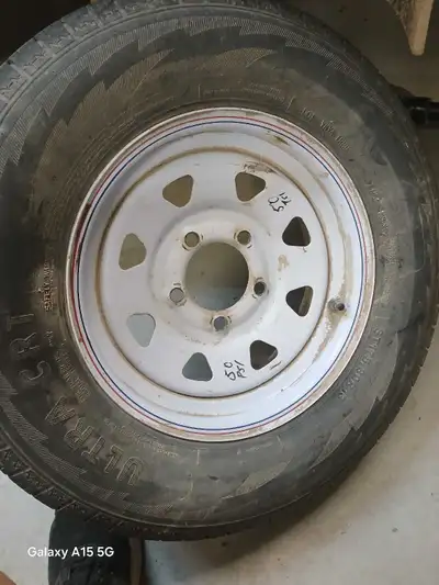 This is a trailer spare tire, size ST175/80R13 on a white rim. It's in used condition, as you can se...