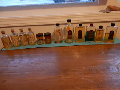 12 vintage bottles. Some are full, some have cork tops, and fancy written labels. See pictures for d...