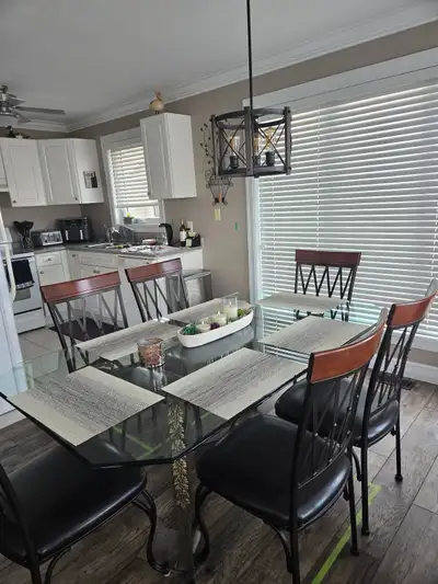 Glass table and 6 chairs. Chairs are beautiful leather, metal and wood with adjustable front feet fo...