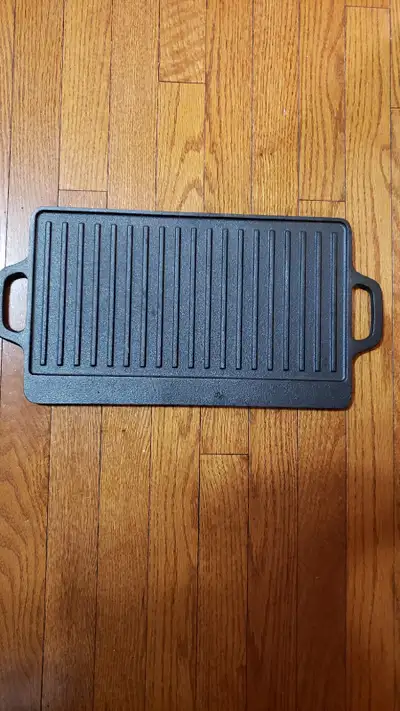Brand new in the carton 15 inch reversible cast iron grill and griddle. Made by Olympic BBQ. Use it...