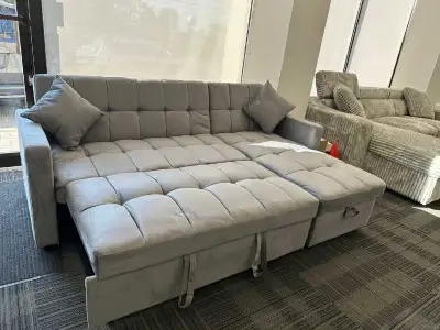 This used grey sectional sofa bed features a versatile pull-out design, perfect for accommodating gu...