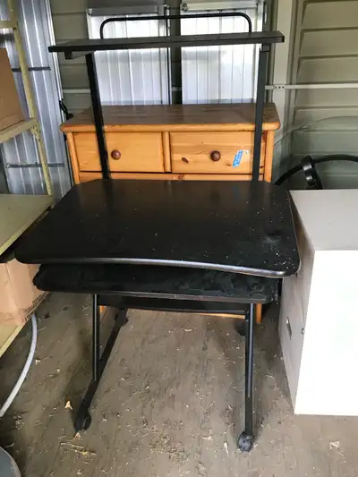 This used computer desk features a black top, a slide-out keyboard tray, and a top shelf for monitor...