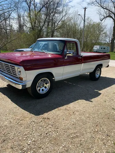This is a classic '67 Ford F250 pickup truck, featuring a striking red and white exterior, a well-ma...