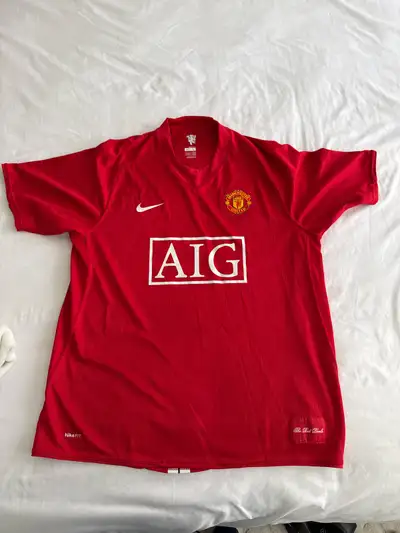 This vintage Manchester United AIG jersey by Nike is a must-have for any fan! It's in good condition...