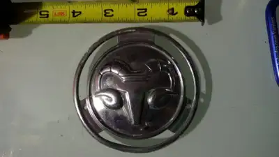 Ram emblem stamped chrome metal. See pictures.
