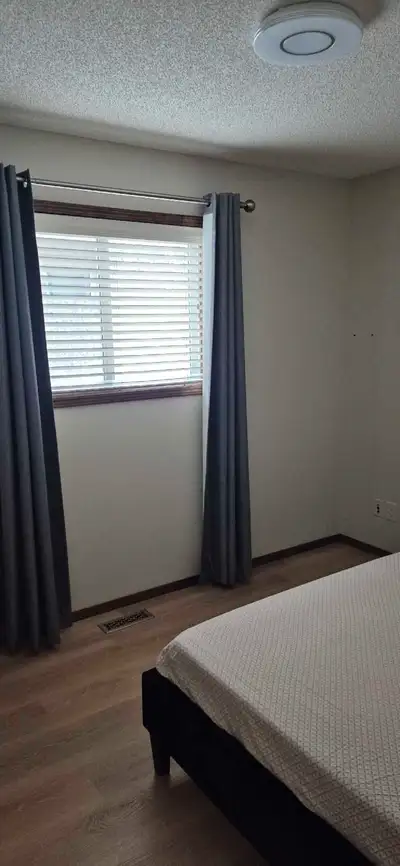 Cozy room available for rent, featuring a comfortable bed with a stylish headboard, perfect for a go...