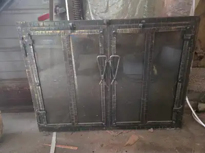 Vintage cast iron fireplace doors in good condition. Definitely in need of a good cleaning. Not sure...