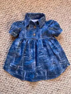 Toddlers spring dress in a denim print. Cotton fabric in sizes 2,3. Dress has collar, puffy sleeves,...