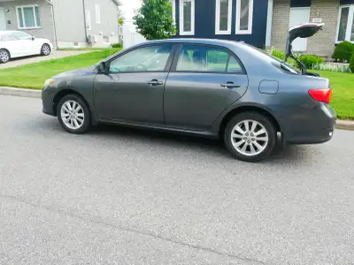 Toyota Corolla LX modèle de luxe, identifiable, entre autres, par les garnitures intérieures imitati...