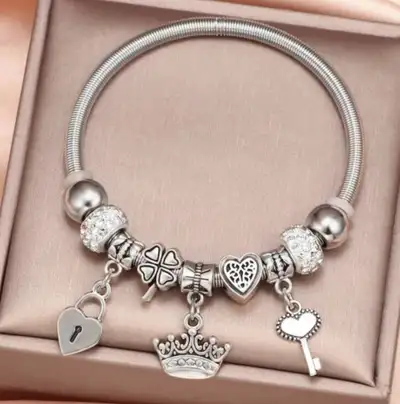 Add a touch of charm to your wrist with this used bracelet, adorned with heart, clover, and crown ch...