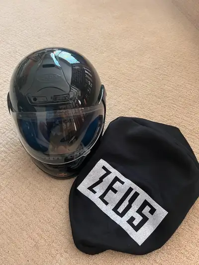 Two approved motorcycle helmets with carrying bags. The Zeus helmet is XS and the HJC Hemet is XL. A...