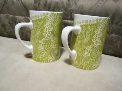 Two brand new matching Starbucks Mugs. Pretty green and white lace design. Would make a great gift....